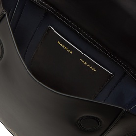 Wandler black calf leather top handle bag interior, showing navy lining and gold-print branded card slot