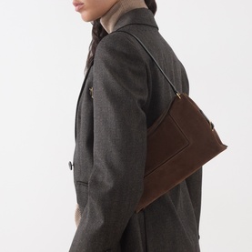 Model carrying Wandler Penelope Suede Slouch Shoulder Bag in Palissander Suede, worn over shoulder, styled with grey wool coat.