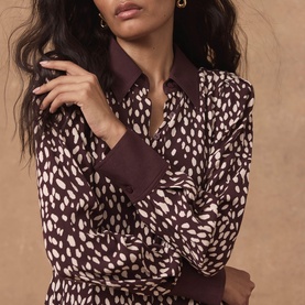 Model wearing Mint Velvet red abstract spot print dress with contrast collar and cuffs, long sleeves