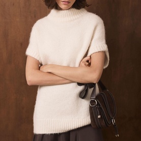 Model wearing Mint Velvet cream fluffy knit short-sleeve roll-neck top, styled with a dark brown mini shoulder bag.