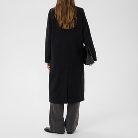 Model wearing Kaffe black deep longline coat, back view, styled with grey wide-leg trousers and black bag.