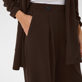 Model wearing Kaffe Phoebe High-Rise Wide Leg Trousers in Coffee Bean, styled with matching brown blazer. Elasticated waist, front pleat detail.