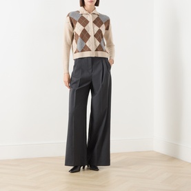 Model wearing Max Mara Studio Ecru wool cashmere argyle cardigan with open collar, styled with dark wide-leg trousers and black heels.