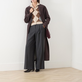 Model wearing Max Mara Studio Ecru wool-cashmere argyle cardigan, styled with dark brown longline coat and charcoal wide-leg trousers.