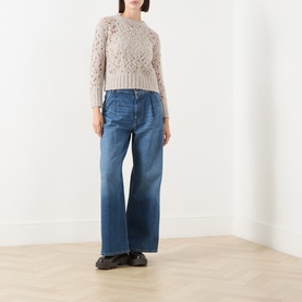 Model wearing Max Mara Studio Ladino Open-Knit Sweater in Natural, styled with wide-leg blue jeans and black loafers
