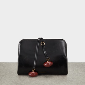 Victoria Beckham black leather clutch bag with gold-tone hardware and burgundy stone charm detailing on shoulder strap