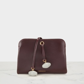 Victoria Beckham Dark Burgundy leather clutch bag with gold-tone ring detail and white stone charm on single top handle
