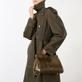 Model carrying Victoria Beckham Sloane Frame Shoulder Bag in dark olive leather, gold-tone hardware, worn as shoulder bag