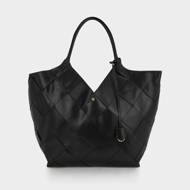 Anine Bing black woven leather tote bag with single top handle, gold-tone stud detail, and tassel accent