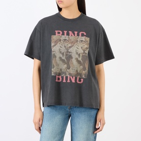 Model wearing Anine Bing black oversized cotton T-shirt with pink BING BING graphic and camo print motif, styled with blue jeans