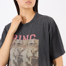 Model wearing Anine Bing black cotton T-shirt with faded tiger graphic print and pink logo text, relaxed oversized fit