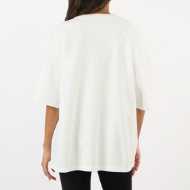 Model wearing Anine Bing white oversized cotton T-shirt, shown from behind highlighting dropped shoulders and relaxed fit.