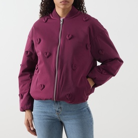 Model wearing Fabienne Chapot Hearty 3D Heart Appliqu&eacute; Bomber Jacket in Brigitte Bordeaux with zip fastening, styled with blue jeans