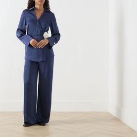 Model wearing Fabienne Chapot Maritime Blue shirt with wide-leg trousers, belted waist and flared cuffs, full-length shot.