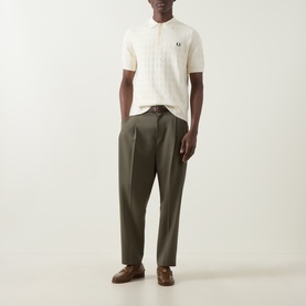 Model wearing cream textured short-sleeve polo shirt with band collar, styled with olive trousers and brown leather shoes
