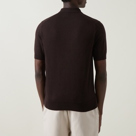 Model wearing Fred Perry Laurel Wreath Logo Polo Shirt in Rich Brown, rear view, knitted cotton with polo collar and short sleeves, styled with cream
