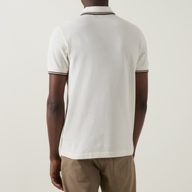 Model wearing Fred Perry Laurel Wreath Logo Twin Tipped Polo Shirt in Ecru with brandy and green tipped trims, back view, styled with khaki trousers