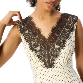 Model wearing Whistles dress in multi, featuring cream and black polka dot fabric with deep V-neck and dark brown lace trim detail.