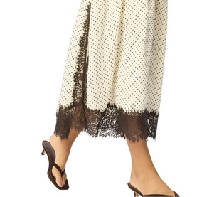 Model wearing Whistles multi polka dot midi dress with dark lace hem trim, styled with brown strappy kitten heel sandals.