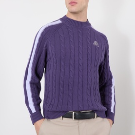 Model wearing Pellador purple cable-knit cotton jumper with white stripe sleeve detail and small chest logo, styled with beige trousers.