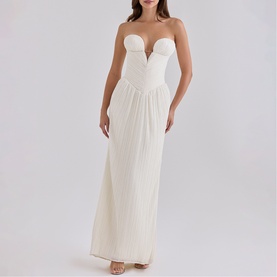 Model wearing House of CB white strapless maxi dress with sweetheart bust detail and pleated skirt, styled with nude heels