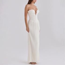 Model wearing House of CB white strapless maxi dress with deep sweetheart neckline and pleated skirt detail