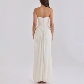 Model wearing House of CB white strapless pleated maxi dress, rear view showing structured bodice and floor-length pleated skirt
