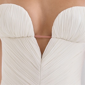 Model wearing House of CB white strapless ruched bodice dress with sweetheart neckline, close-up detail view