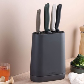 Zyliss Kitchen Knife Block in grey with four multi-coloured handled knives, styled on a wooden surface with food and drink props