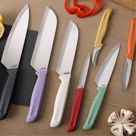 Zyliss Kitchen Knife Set in multicolour handles including grey, lilac, white, red, yellow and green, displayed on wooden board with vegetables