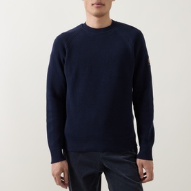 Model wearing Belstaff Bradwell Logo Badge Waffle-Knit Sweater in Dark Ink, crew neck, long sleeves, Phoenix badge on arm, styled with dark trousers.
