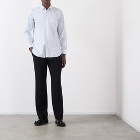 Model wearing Comme Des Garcons Shirt blue striped cotton casual shirt with chest pocket, styled with black trousers and loafers.