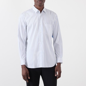 Model wearing Comme Des Garcons Shirt blue and white vertical stripe cotton casual shirt with chest pocket, styled with black trousers