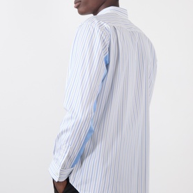 Model wearing Comme Des Garcons Shirt blue striped cotton casual shirt, shown from rear three-quarter angle highlighting back panel detail