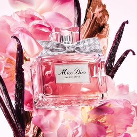Dior Miss Dior Eau de Parfum bottle with silver bow, surrounded by pink florals and vanilla pods