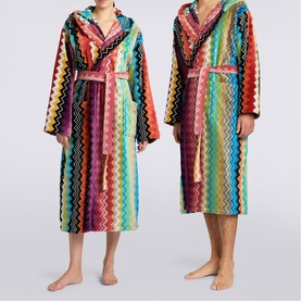 Two models wearing Missoni multicolour zigzag stripe hooded robes in towelling fabric with tie belts, shown full length