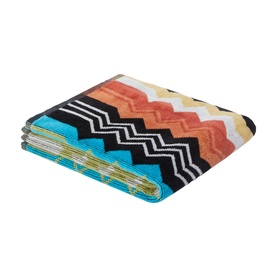 Missoni bath towel in multicolour zigzag pattern featuring turquoise, orange, black, white and yellow chevron stripes, folded flat.