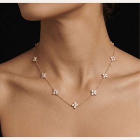 Model with Lynott Jewellery gold chain necklace featuring multiple diamond-set four-petal flower stations