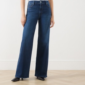 Model wearing Paige Wide Leg jeans in Admission dark blue denim, styled with black leather shoes. High-rise fit with a relaxed, full-length leg.