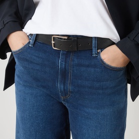 Model wearing Paige Wide Leg jeans in Admission blue denim, styled with a black blazer, white tee, and black leather belt.