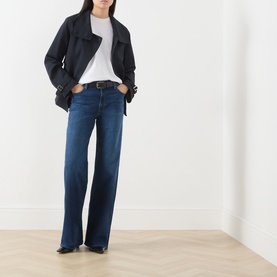 Model wearing Paige Wide Leg jeans in Admission dark blue denim, styled with a white tee and black jacket.