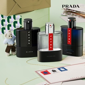 Prada Luna Rossa fragrance set, three black and clear bottles with red accents, styled with gift wrapping and a small teddy bear
