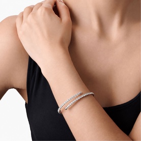 Model with Lynott Jewellery silver double-wrap crystal-set bangle bracelet, worn on wrist against black top.