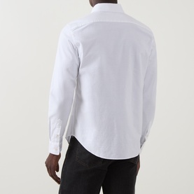 Model wearing Belstaff white cotton casual shirt, shown from rear, with dark trousers. Long sleeves, curved hem.