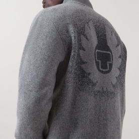 Model wearing grey fleece jacket, rear view showing large dark Belstaff logo graphic on back