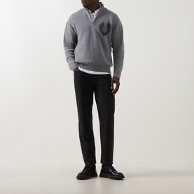 Model wearing grey half-zip knit sweater with chest emblem, styled with white shirt, black trousers and black leather shoes