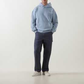 Model wearing Belstaff Mist Blue cotton hoodie, styled with navy carpenter trousers and white trainers