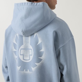 Model wearing Belstaff Mist Blue cotton hoodie, rear view showing tonal white logo graphic print on back