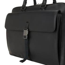 Calvin Klein Commuter Logo Briefcase in black with gunmetal engraved buckle closure, front flap pocket, and top handles visible.