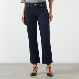 Model wearing FRAME DENIM Slim Jeans in Rinse dark indigo wash, cropped straight leg, paired with black T-bar heels.